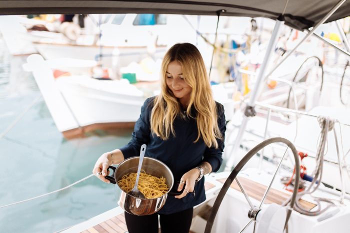 Mujer haciendo comida a bordo de un barco