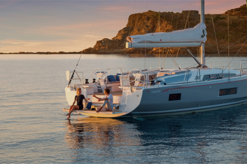 Pareja disfrutando de un momento de relax a bordo de un catamarán fondeado en una bahía tranquila