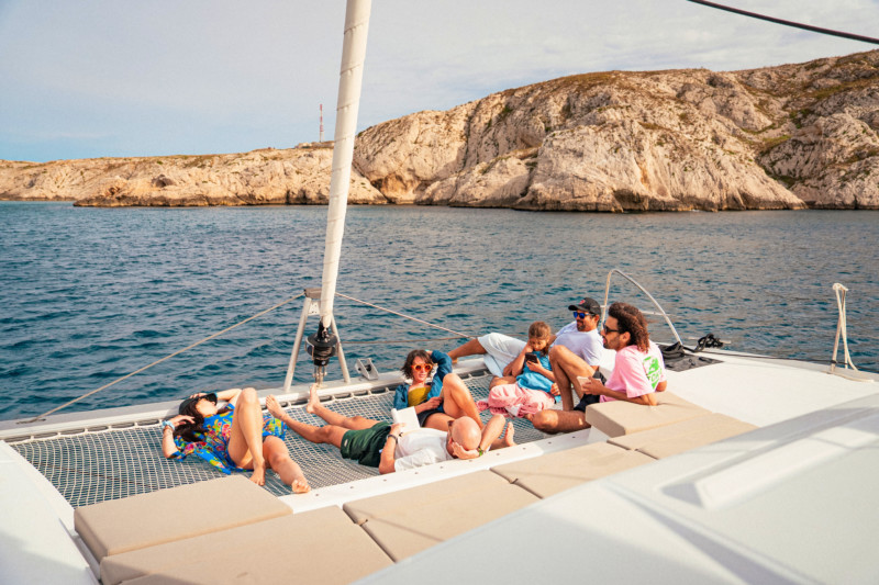 Grupo de personas relajándose a bordo de un catamarán fondeado
